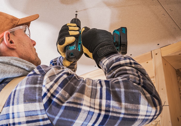 technicial installing an AC using a cordless drill